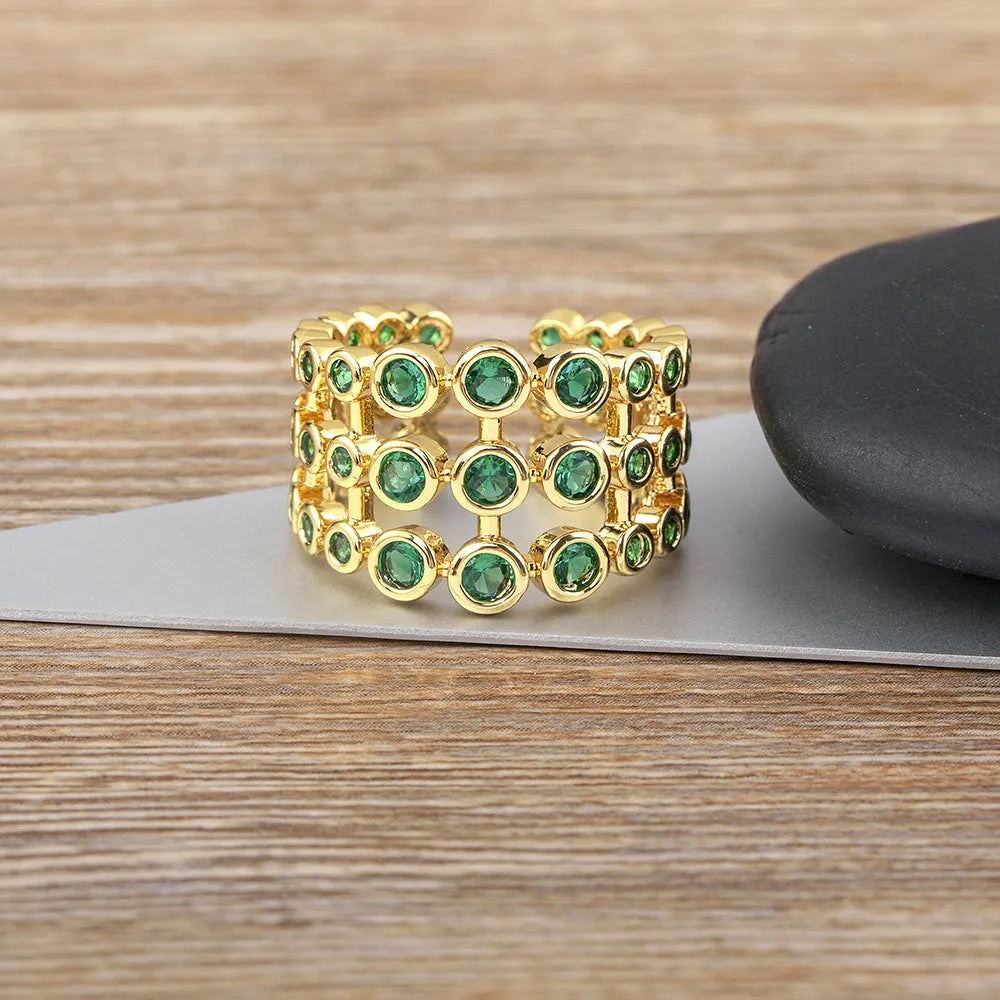 Copper ring with 18K gold plating showing three-layer exaggerated design with zircon stones
