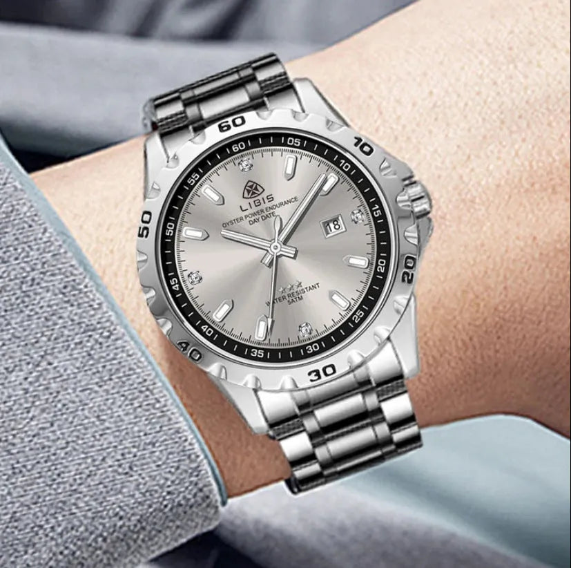 Men's silver quartz watch with luminous hands and stainless steel strap on wrist
