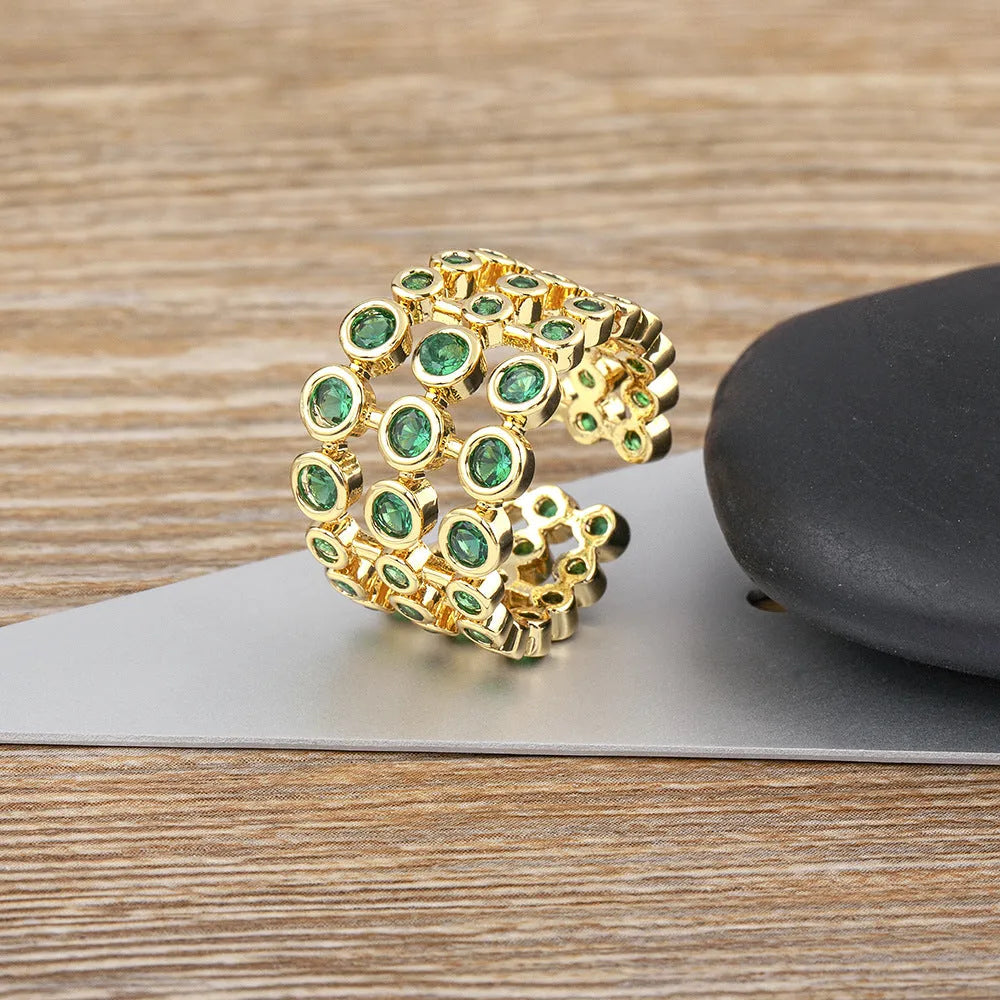 Copper ring with 18K gold plating showing three-layer exaggerated design with zircon stones