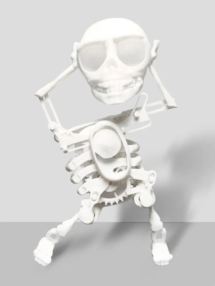 3D printed dancing skeleton gravity toy in pink and white, 22cm tall, on a desk