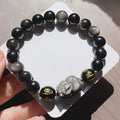 Men's silver stone beaded bracelet with zodiac and Chinese proverb charms on a wrist.