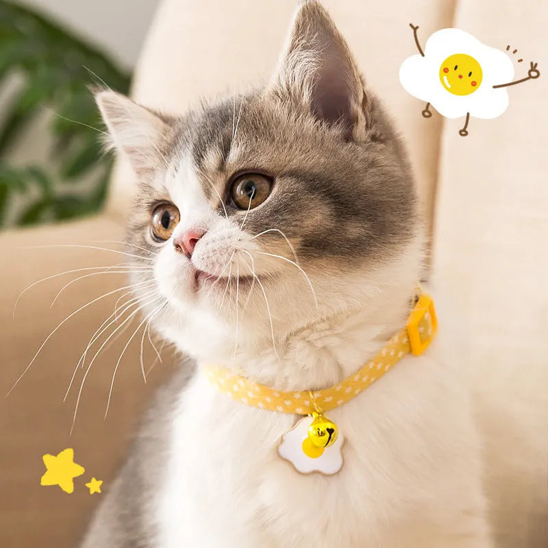 Green adjustable cat collar with bell pendant and bow tie on a small dog