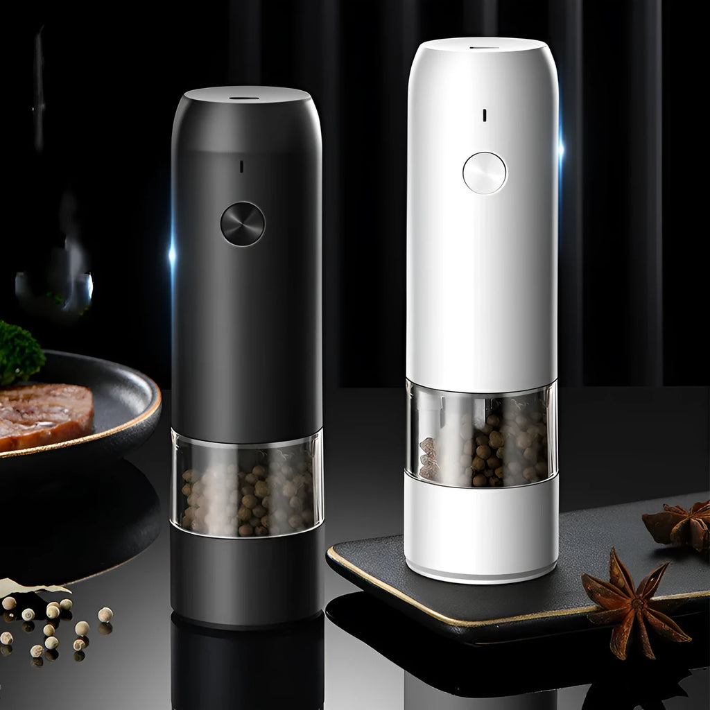 Black and silver electric salt and pepper grinders with clear acrylic bodies on a kitchen counter.