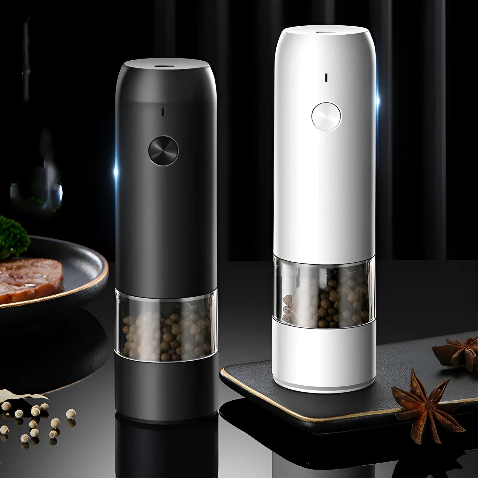 Black and silver electric salt and pepper grinders with clear acrylic bodies on a kitchen counter.