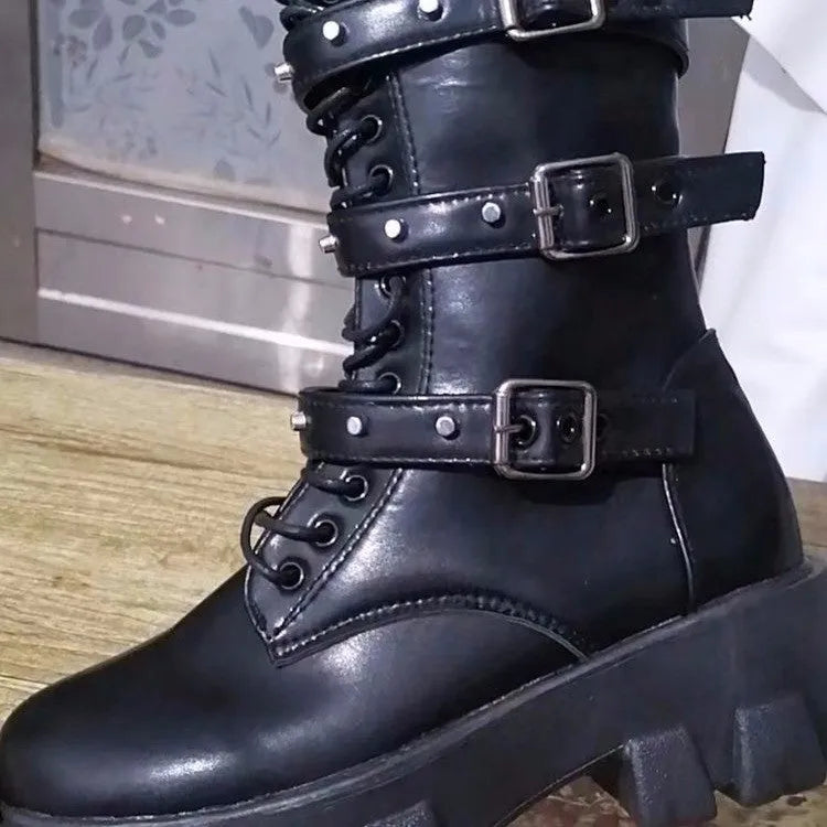 A pair of women's black mid-calf knight boots with a side zip and a large metal buckle strap.