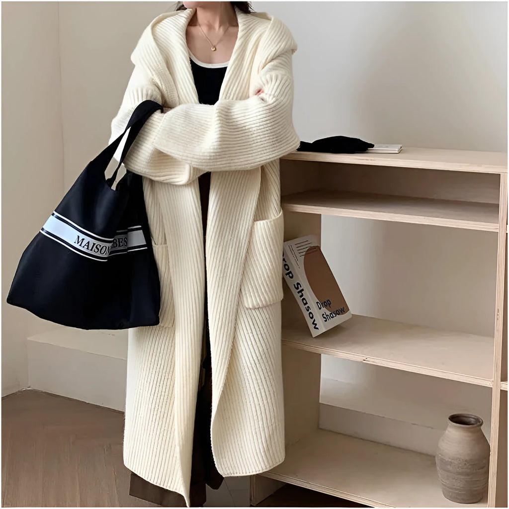 Loose grey hooded sweatshirt cardigan coat with raglan sleeves on a hanger.