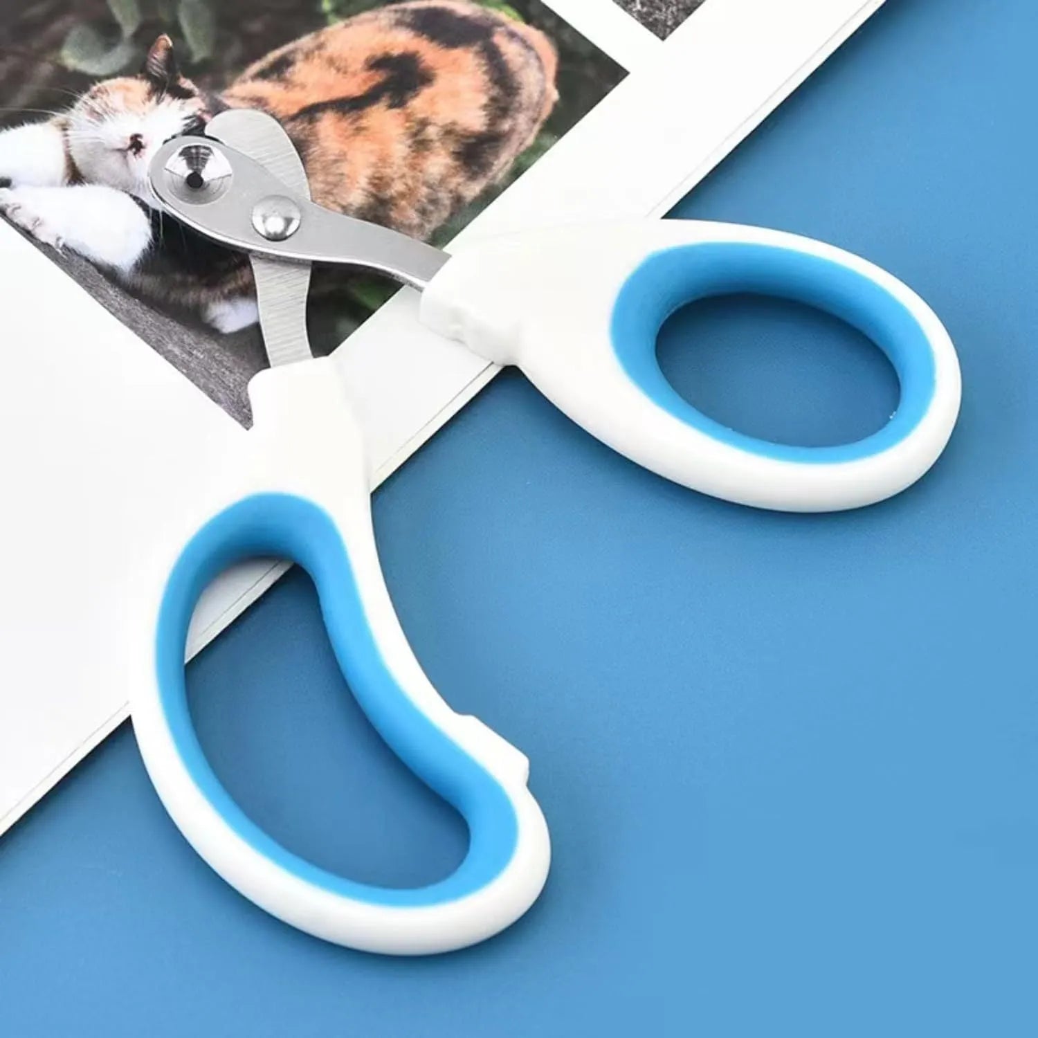 Blue pet nail clippers with a circular cutting hole and cushioned non-slip handles.