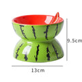 White ceramic raised cat bowl with tilted wide dish and decorative pattern, shown on a table.