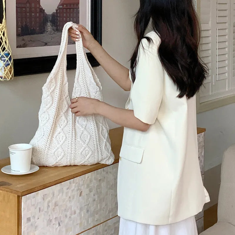 Women's retro-style hollow-knitted wool yarn tote bag in a solid colour, showing double shoulder straps.