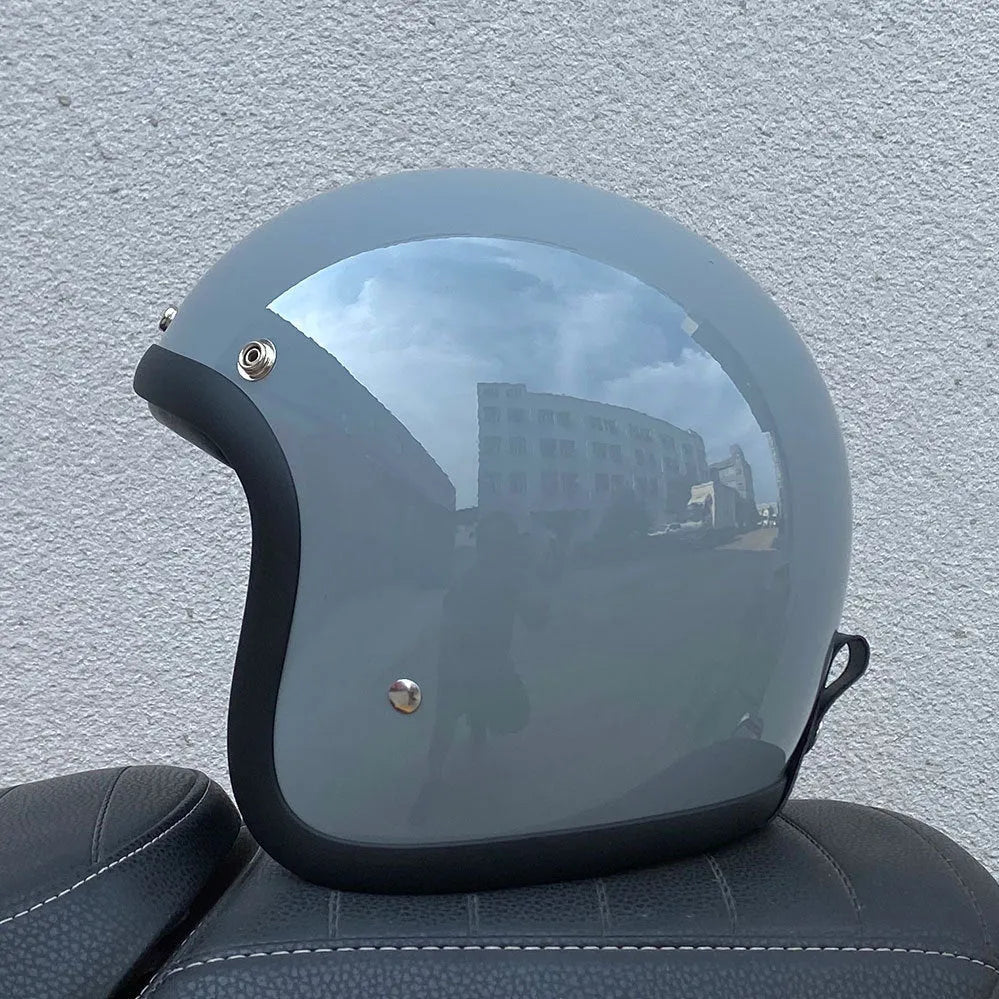 A retro-style fibreglass half motorcycle helmet shown in a cement grey colour, suitable for adult commuting.