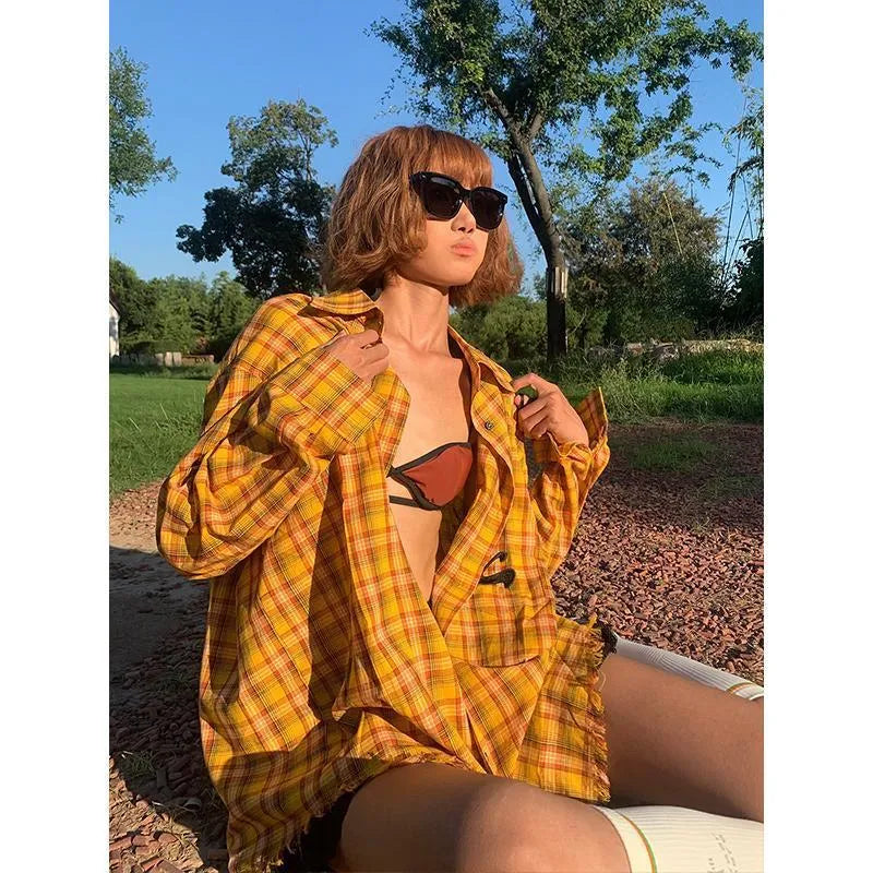 A loose-fitting dopamine yellow plaid shirt with a cardigan style, shown on a hanger.