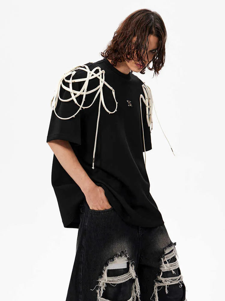 Black loose fit short-sleeve T-shirt with padded shoulders and decorative rivet ribbon detail on a hanger.