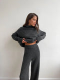 Women's knitted suit with side-slit sweater and matching trousers in acrylic fabric