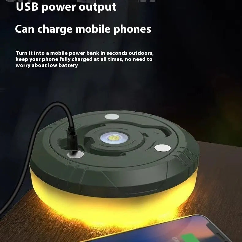 Charging multifunctional camping lantern with warm and colourful light modes on a campsite table