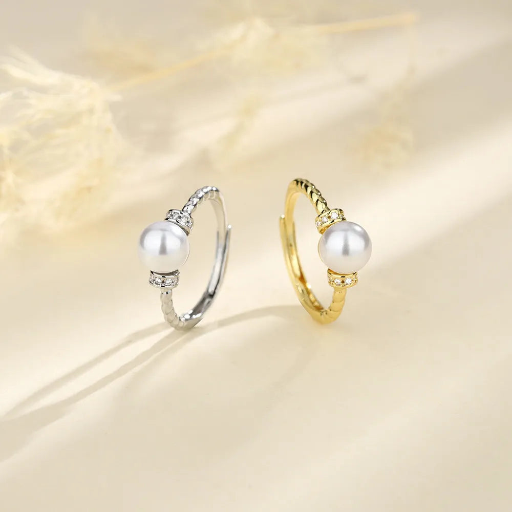 Adjustable antique twist copper ring with a central pearl inlay, shown in gold and silver tone finishes.
