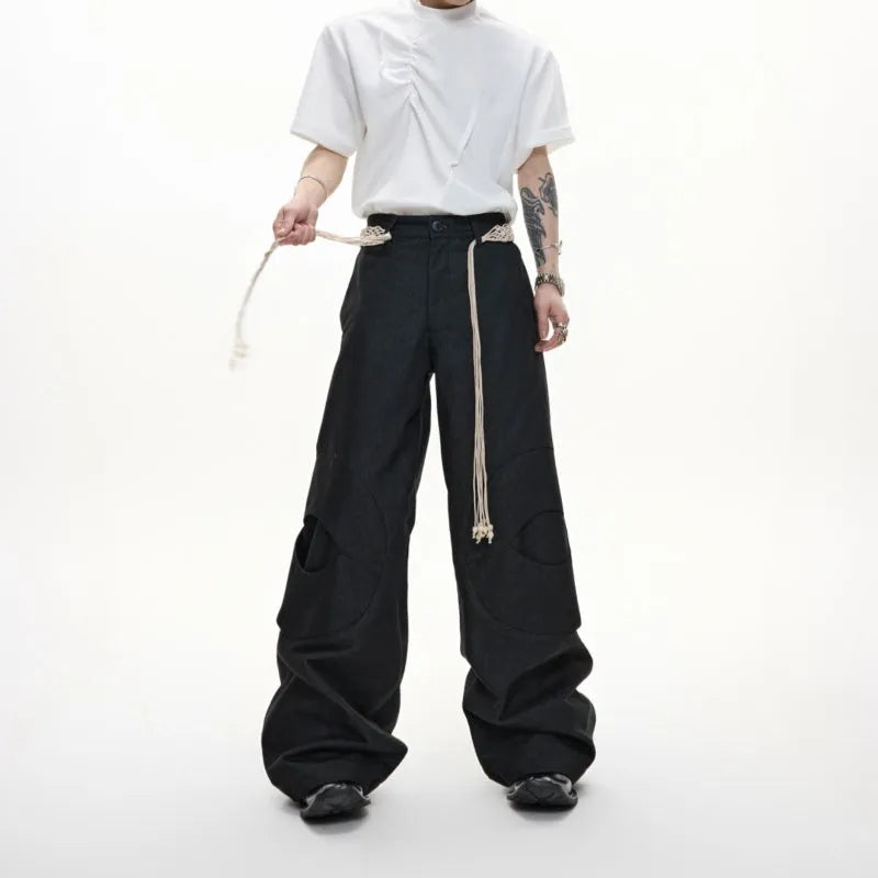 Men's dark coloured straight-leg jeans with heavy 3D cutting, belt-loop stitching, and decorative zipper details