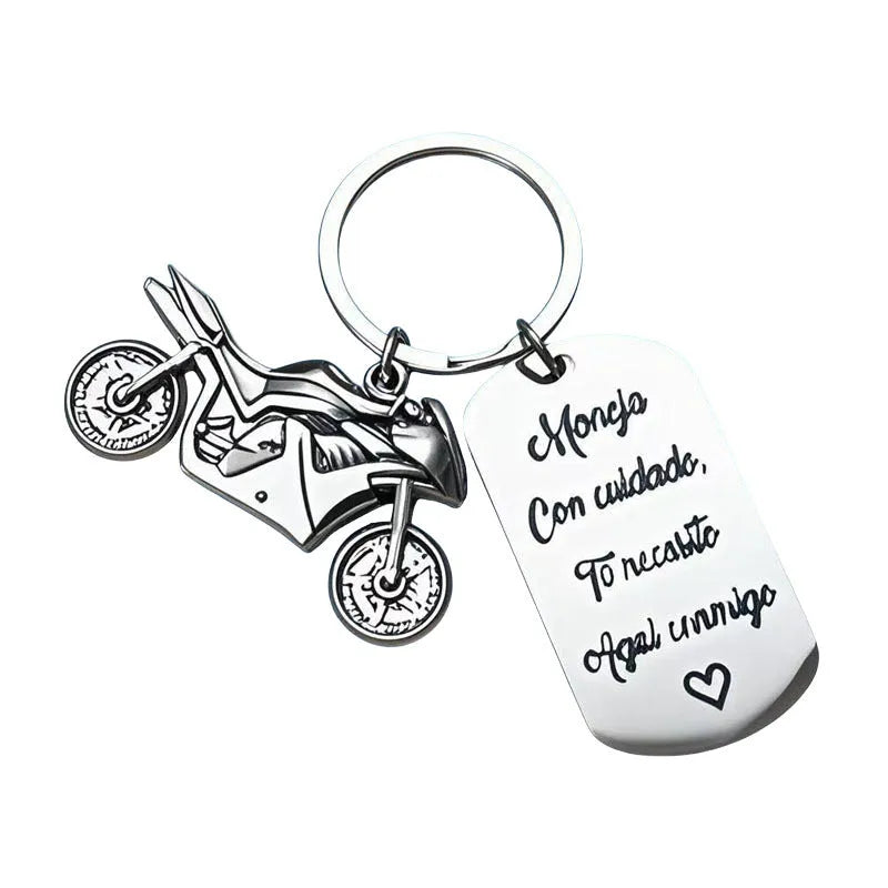 Stainless steel motorcycle keychain with inspirational design, shown with its included flannel storage bag.