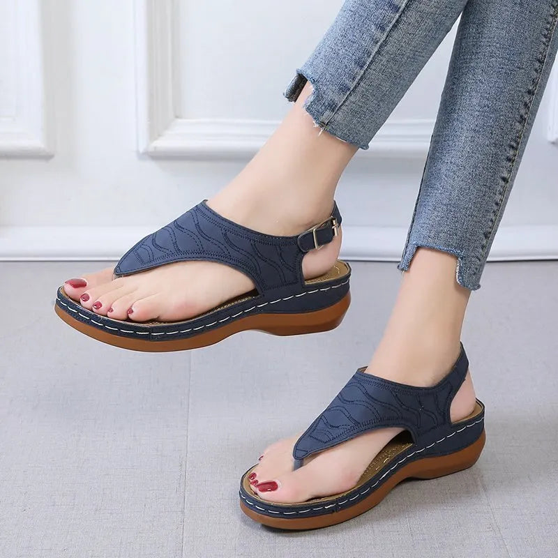 Women's casual wedge heel flip flop sandals with an adjustable buckle strap in a solid colour.