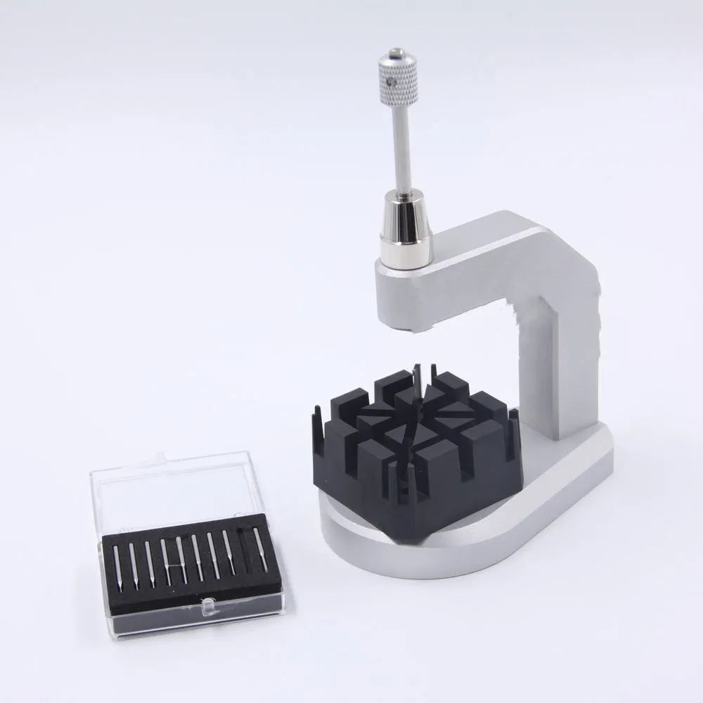 Silver tool steel press strap removal tool for watch bands and jewellery on a grey background.