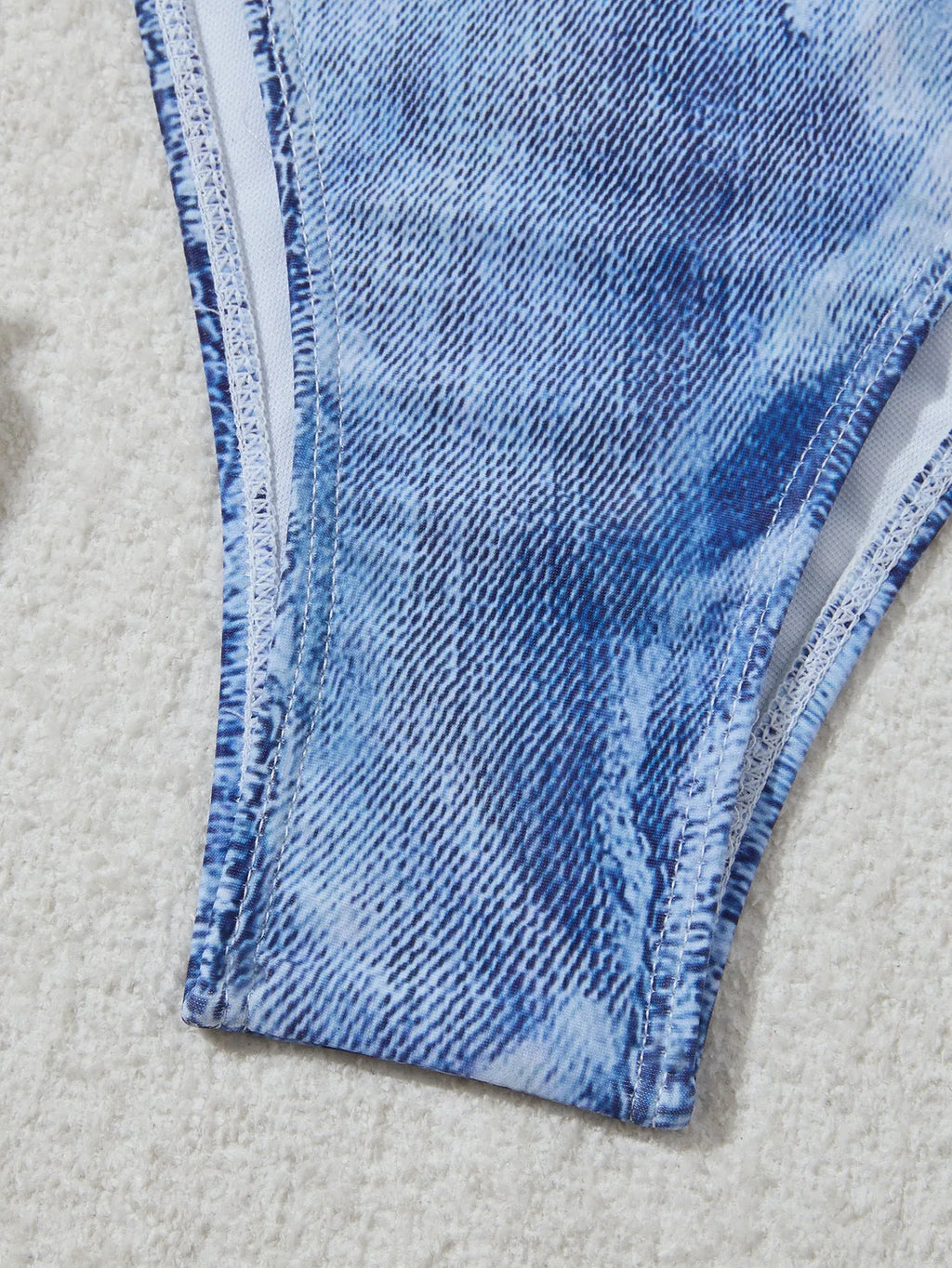 Denim blue women's bikini set with printed strap design on a hanger.