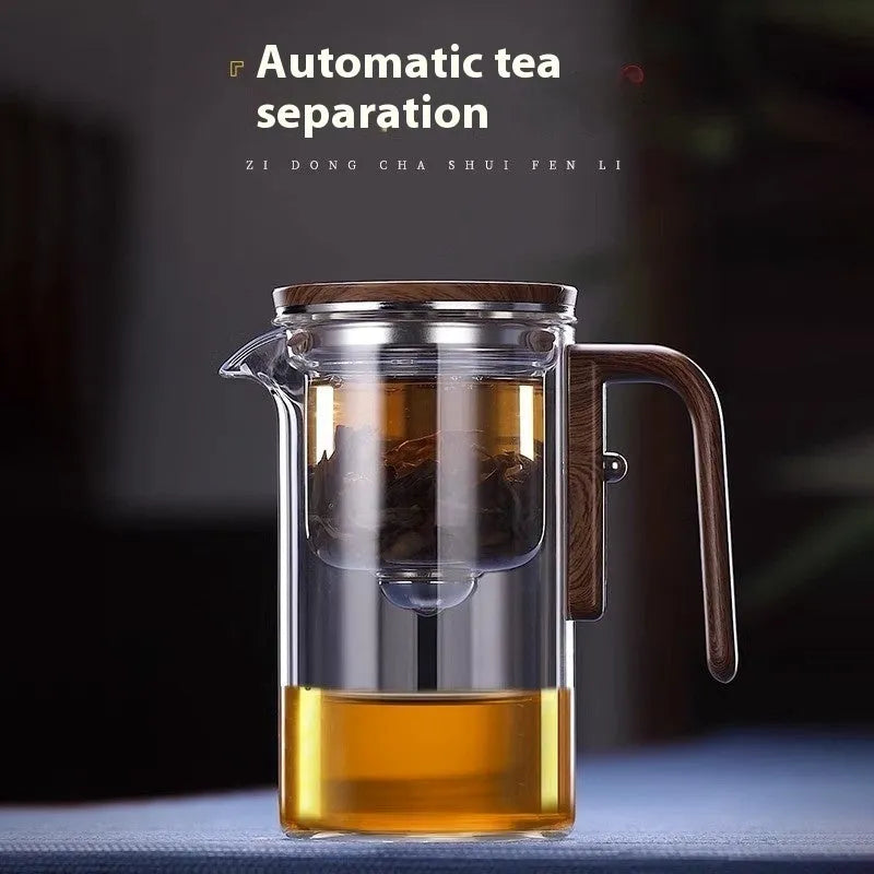 Glass teapot with wooden handle showing magnetic separation mechanism for loose leaf tea brewing