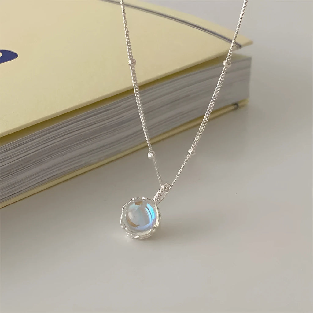 Silver necklace with geometric stone pendant on an adjustable curb chain.