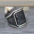 Black alloy ring with copper inlay detail and a single cubic zirconia stone.