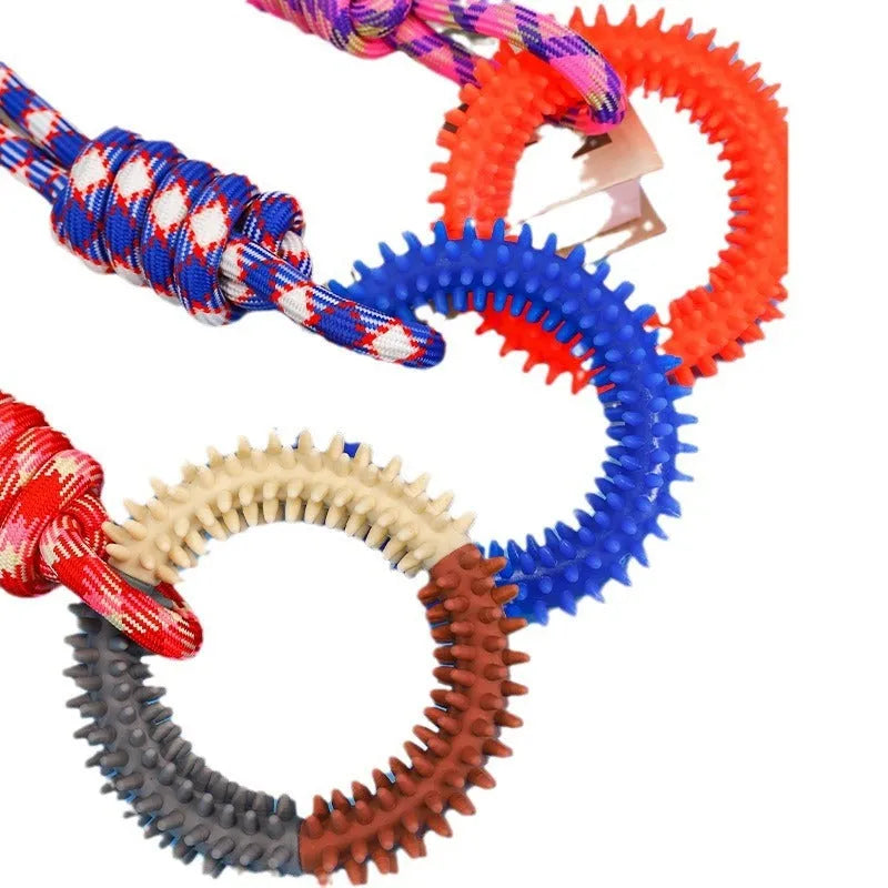 Blue braided rope dog chew toy with a large central knot on a wooden floor