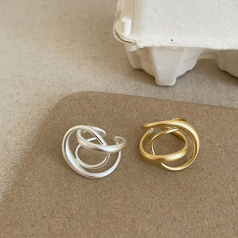 Geometric open ring with three-dimensional interlaced matte metal construction in gold or silver finish