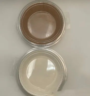 Round white disposable parchment paper liner for air fryer basket with raised edges.