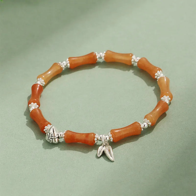Green aventurine bamboo bead crystal bracelet with strawberry quartz and Dongling stones on wrist.