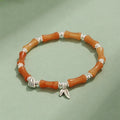 Green aventurine bamboo bead crystal bracelet with strawberry quartz and Dongling stones on wrist.