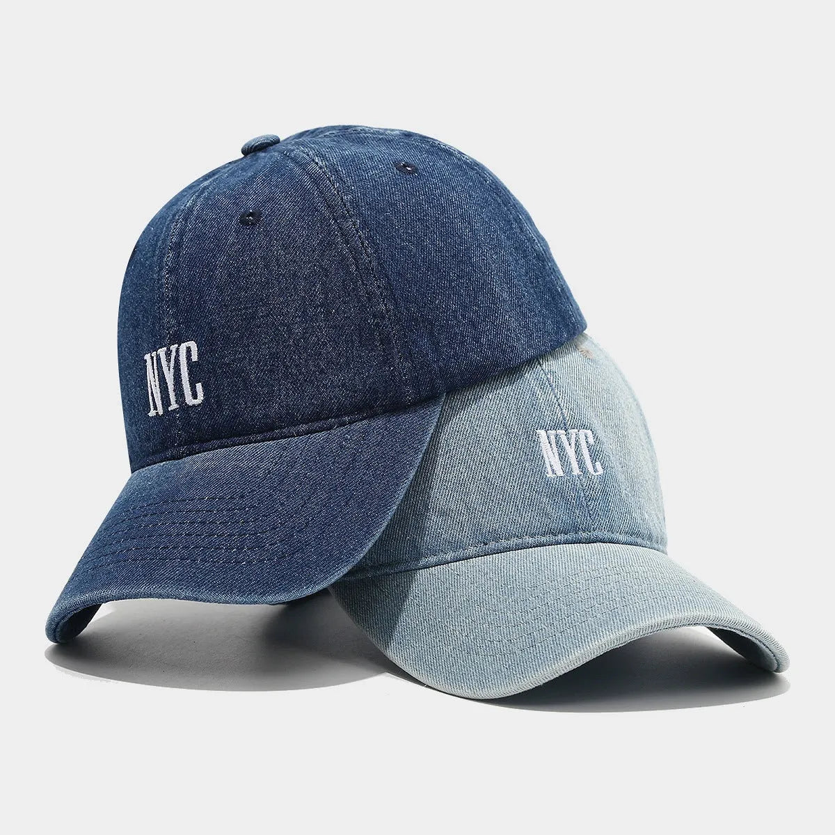 Light blue denim peaked cap with embroidered lettering on the front, showing adjustable strap.