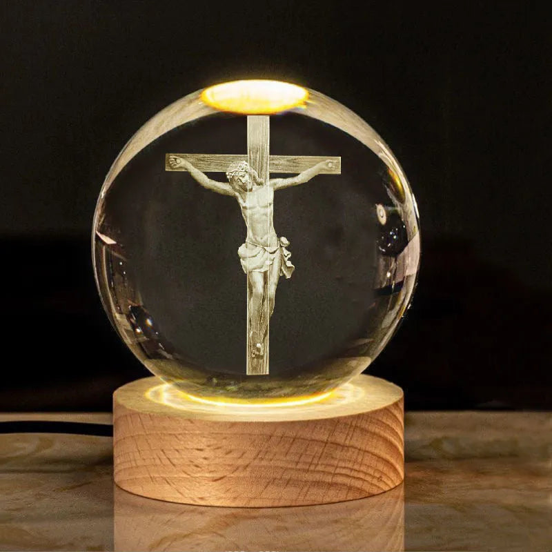 White crystal ball desk ornament on a solid wood base with a warm light, showing religious motif options.