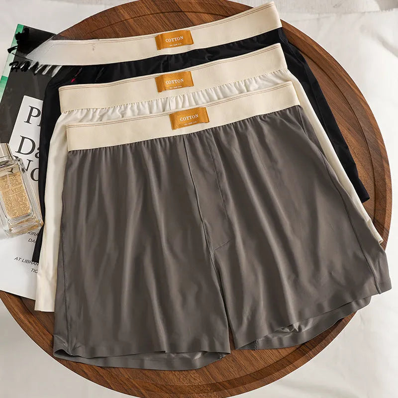 Pack of three men's solid colour ice silk boxer shorts laid flat.