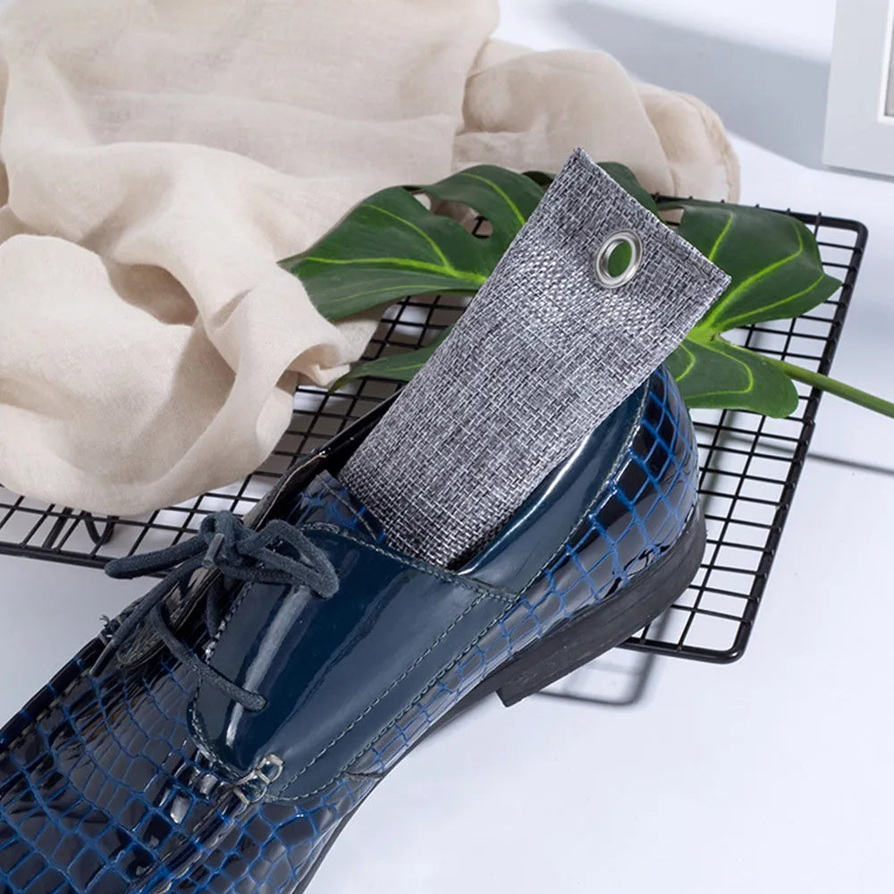 Black activated charcoal deodorising bag made of linen, measuring 16.5cm by 6.5cm.