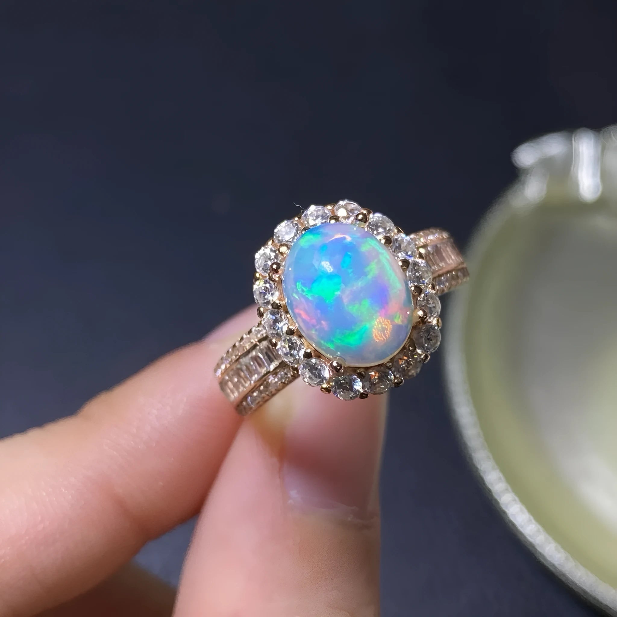 Adjustable opening opal ring in sterling silver with gold tone plating on a model's hand