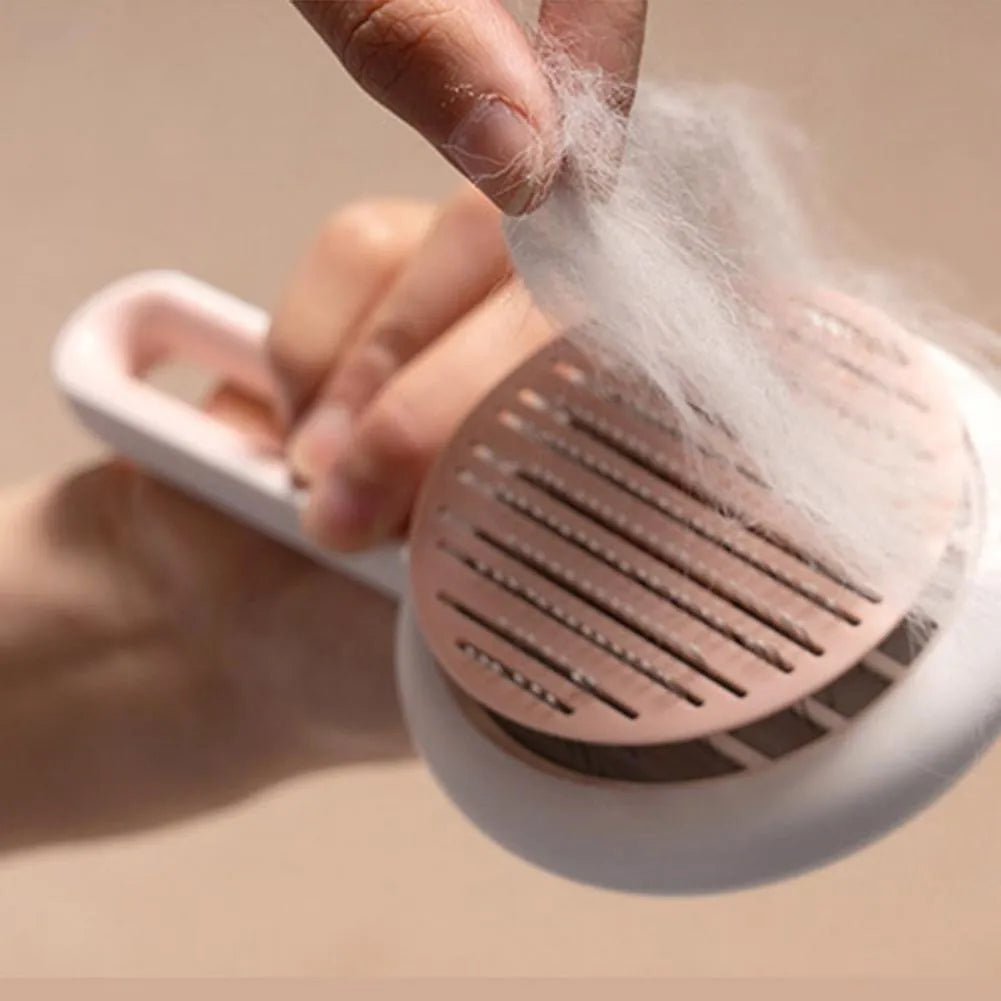 Automatic pet hair remover brush with stainless steel teeth and coloured ABS handle, shown with the hair release button.