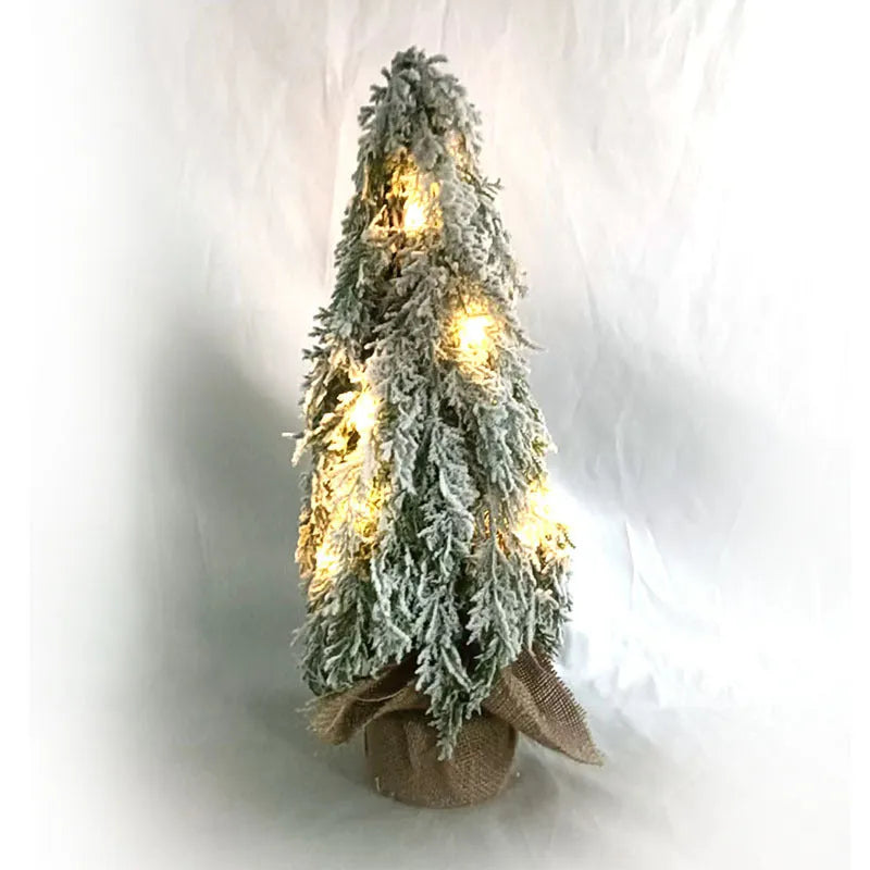 Small 24-inch white snow spray Christmas tree with integrated lights on desktop
