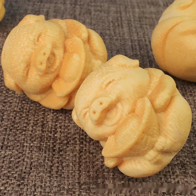 Small cute Fulu Pig bamboo carving ornament on a surface, showing its ingot shape.