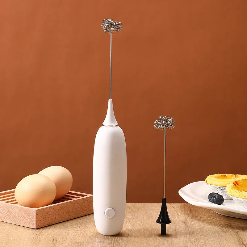 Black and white hand-held electric milk frother blender on kitchen counter
