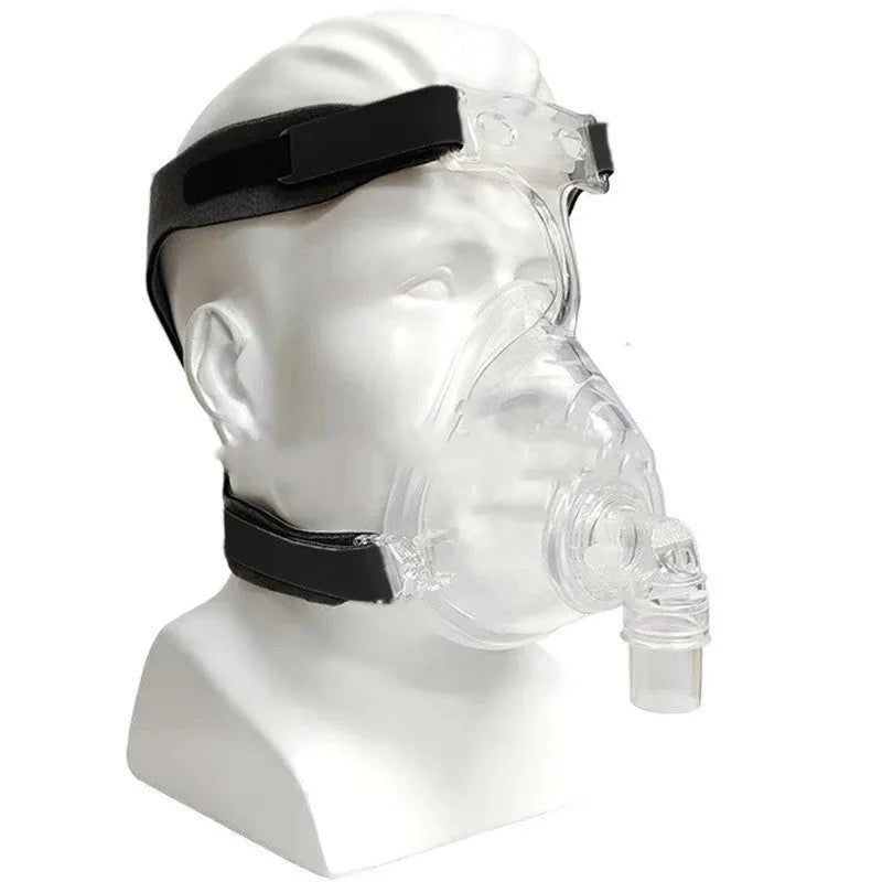 Transparent silicone CPAP breathing mask with headgear and two rotary adapter elbows on a white background.