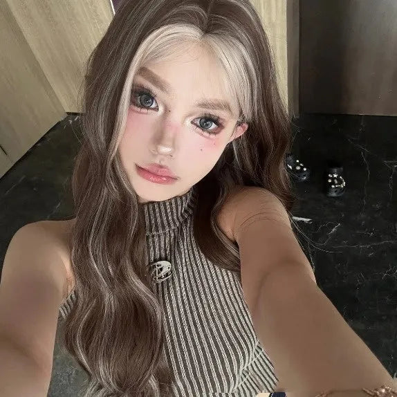 Long curly synthetic wig in gray gold with highlights, shown on a model.