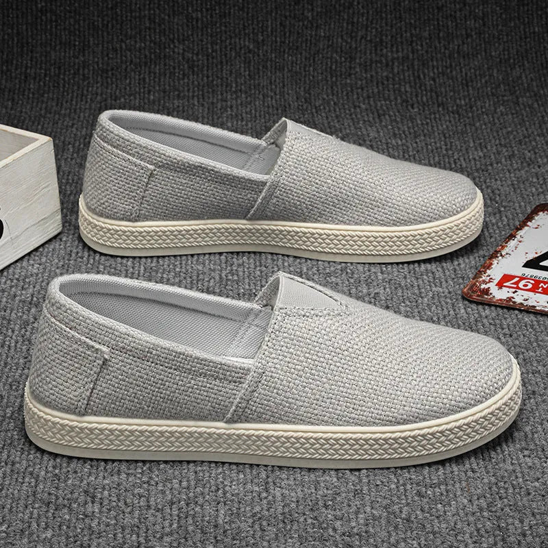 Men's beige linen cloth canvas shoes with round toe and shallow cut on a plain background
