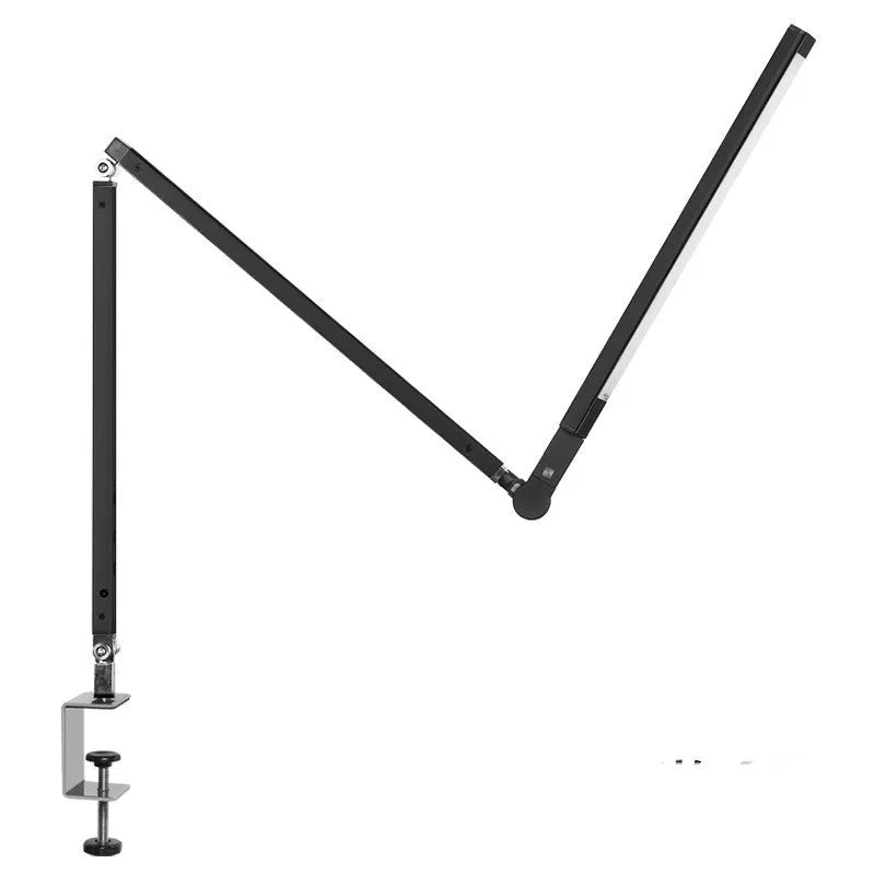 Aluminium clip-on desk lamp with adjustable arm and remote control on a wooden desk.