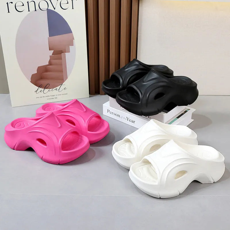 Women's white thick-soled EVA foam slippers with rounded toe on a beach.