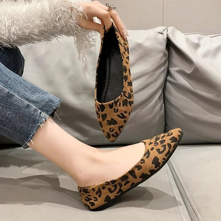 Women's leopard print pointed toe flat pumps with low heel on a white background.