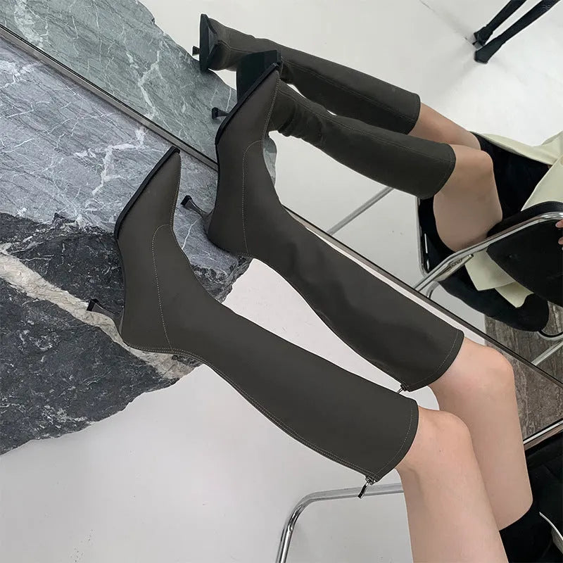 Black women's below-the-knee boots with a pointed toe, stiletto heel, and back zipper.