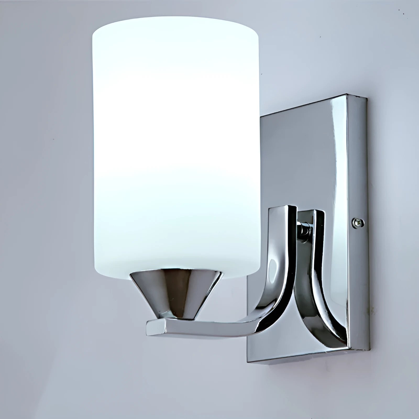 Chrome-plated wall lamp with clear glass shade mounted beside bed