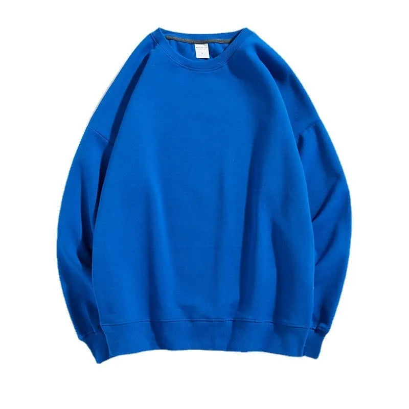 A woman wearing a loose, light blue, cotton off shoulder sweater with long sleeves and a round neck.